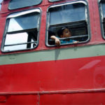 A boy peers out a bus window in Mumbai, India. Photo by gregor_y.
